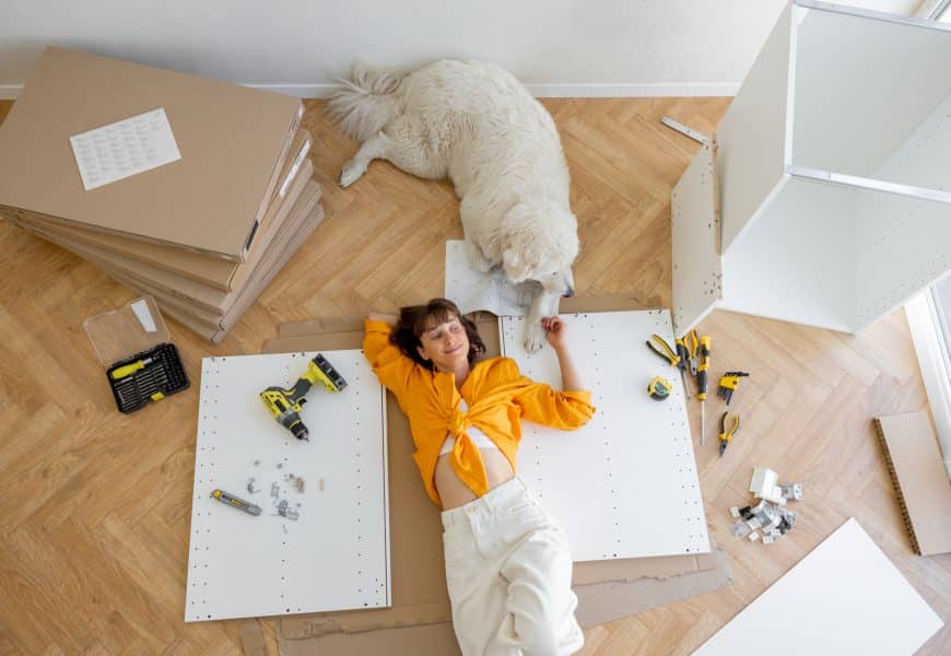 Femme couché sur le sol heureuse avec son chien et des outils
