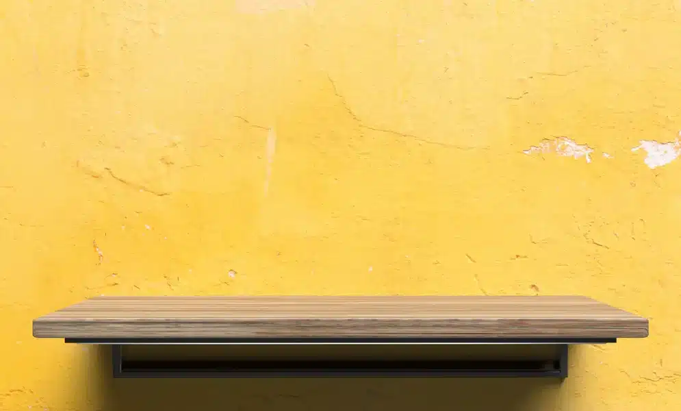 Etagere murale en bois sur un mur jaune