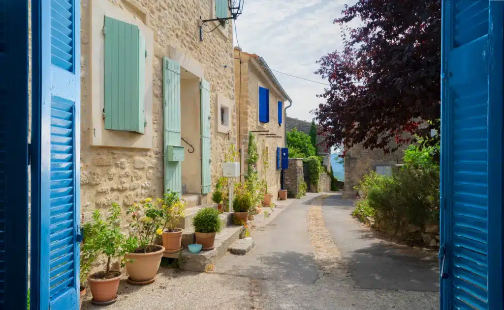 Ruelle d'un village en Provence avec des volets verts et bleus