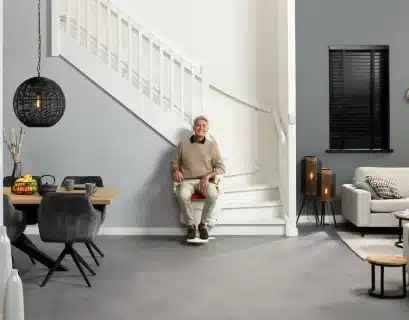 Homme dans son salon assis sur son monte escalier d'occasion
