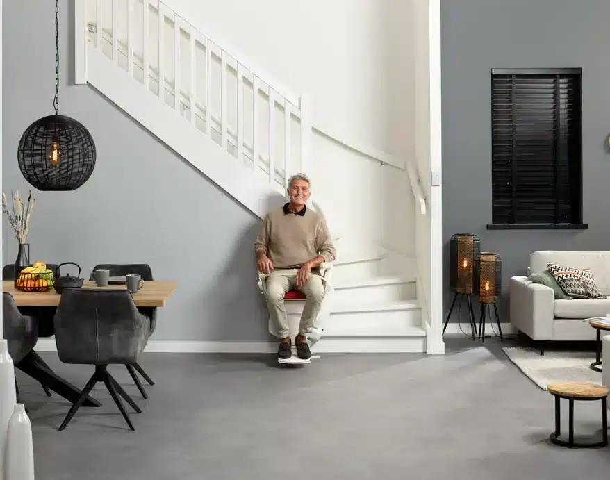 Homme dans son salon assis sur son monte escalier d'occasion