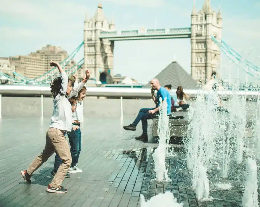 Enfants s'amusants devant des jets d'eau à Londres lors d'un voyage en famille