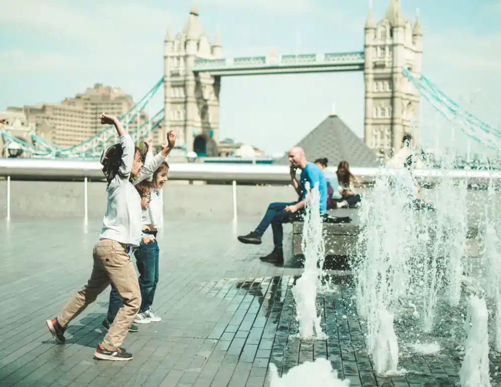 Enfants s'amusants devant des jets d'eau à Londres lors d'un voyage en famille